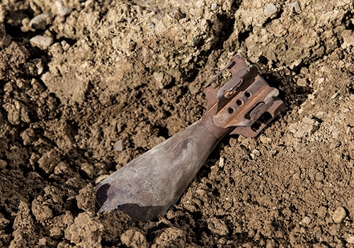 Old rusty military ordinance that didn't explode sticking out of dirt. Explosives testing, Testing explosives, Explosives analysis, Detection of explosives