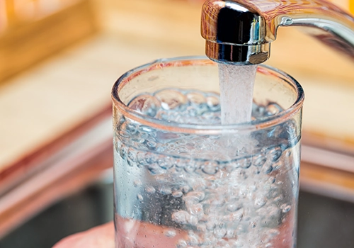 water glass being filled by kitchen water faucet. UCMR, UCMR 5, UCMR 6, UCMR testing laboratory, UCMR 6 lab, UCMR 6 approved laboratories