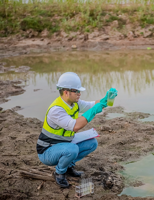 Person taking water sample at contamination site.